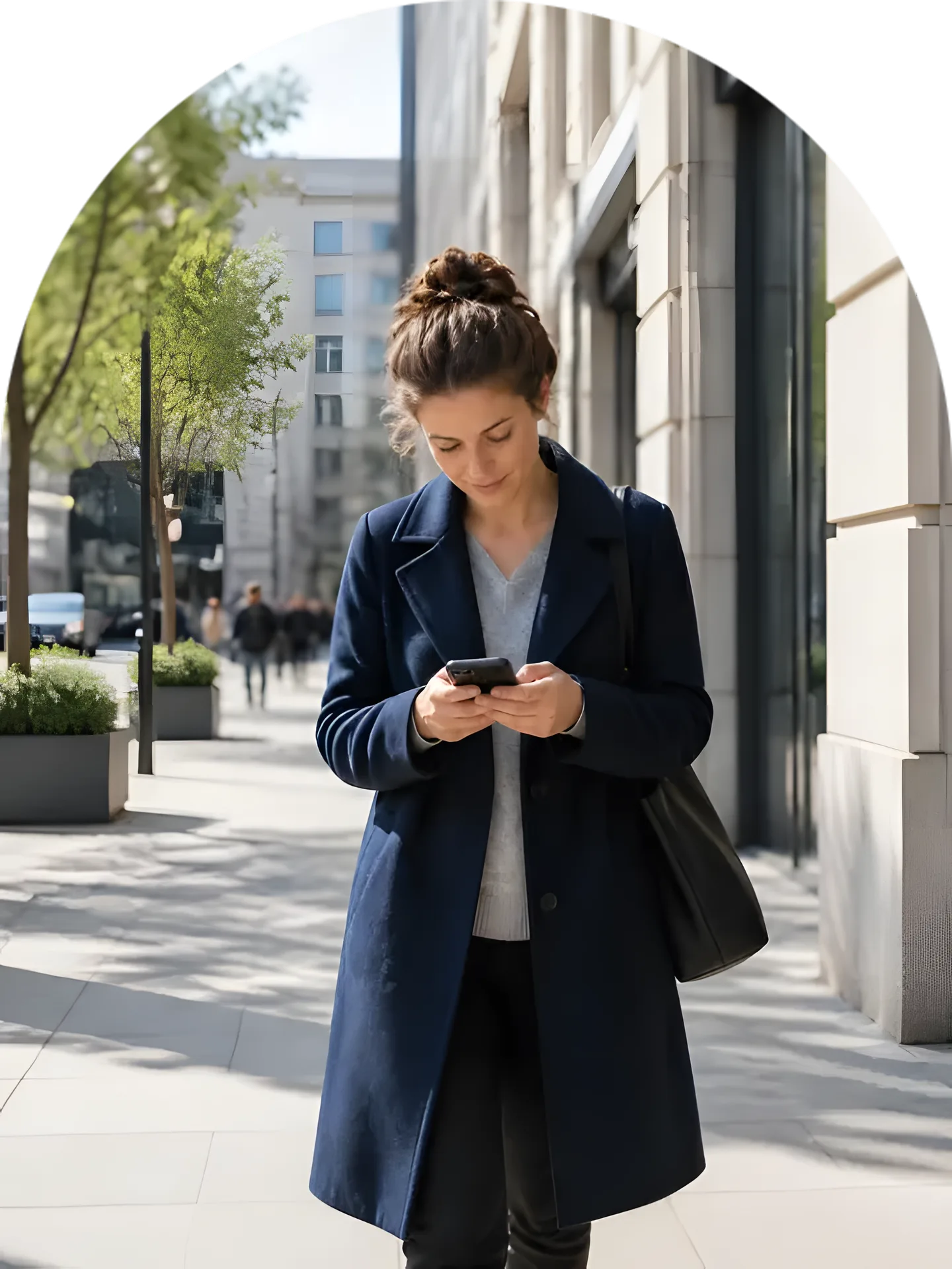 A woman in a city street looking at her phone
